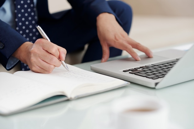 Cropped shot of unrecognizable entrepreneur taking notes 