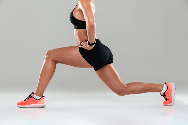 Cropped side view image of a young fitness woman