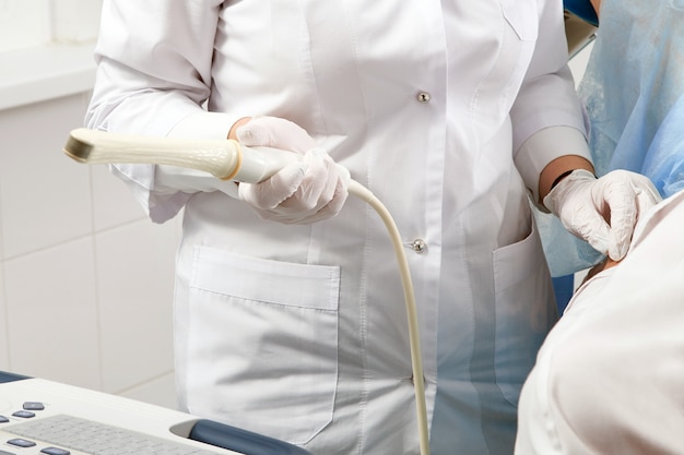 Cropped view of gynecologist holding transvaginal ultrasound wand to exam a woman