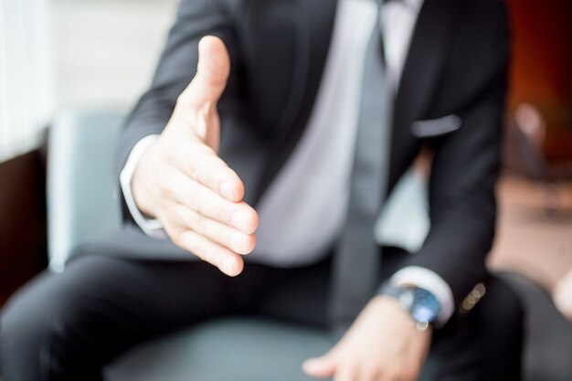 Free photo cropped view of man extending arm for handshake