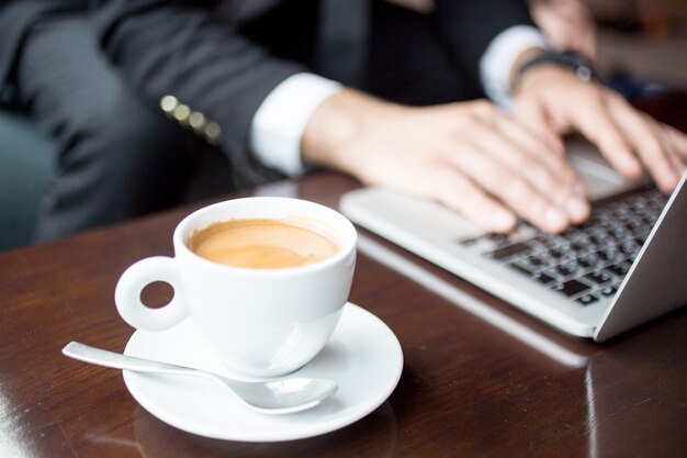 Обрезанный вид человека, работающего на ноутбуке в кафе