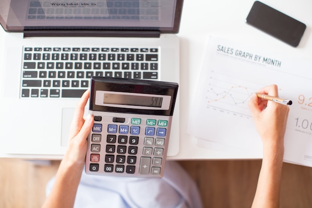 Cropped View of Sales Manager Using Calculator