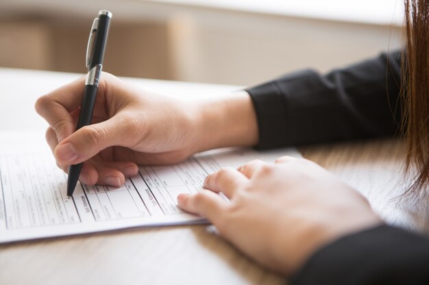 Cropped View of Woman Filling in Application Form