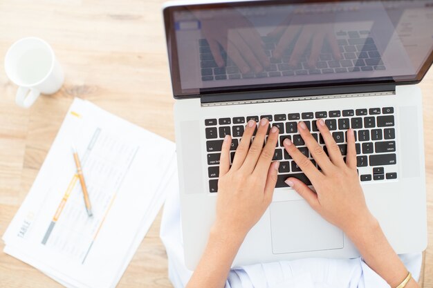 Cropped View of Woman Hands Typing on Laptop
