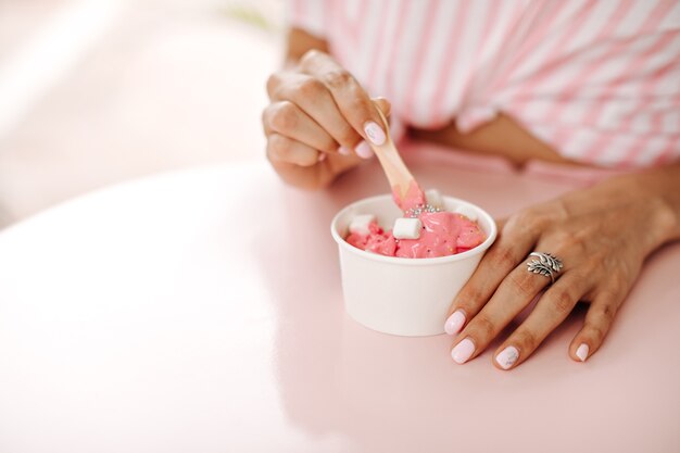 Cropped view of woman with ring eating ice cream. Selective focus of woman enjoying tasty dessert.