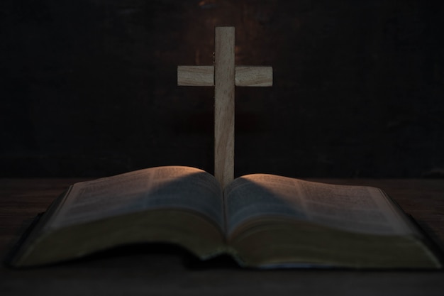 Free photo cross and holy bible on wooden table