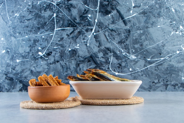 Croutons and small salted fish , on the marble background.