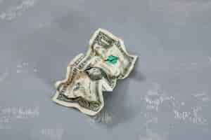 Free photo crumpled dollar banknote on plaster table .