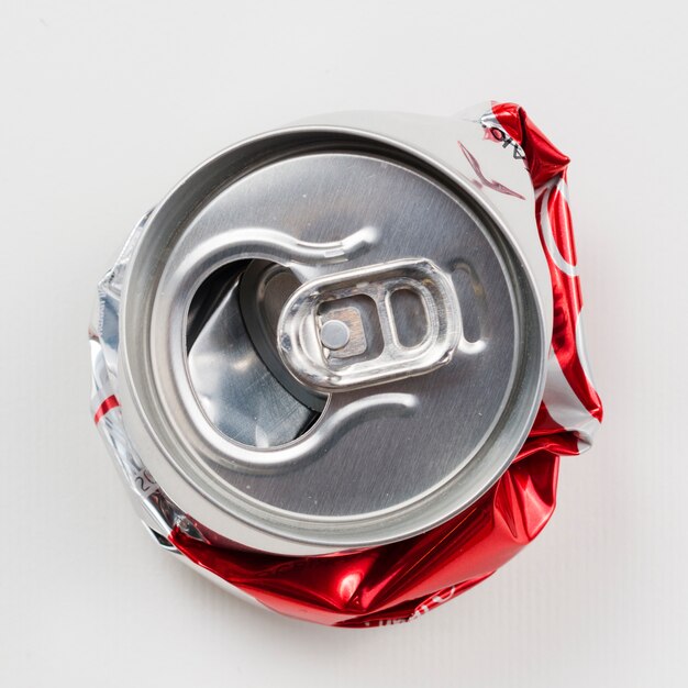 Crumpled drink can on grey background