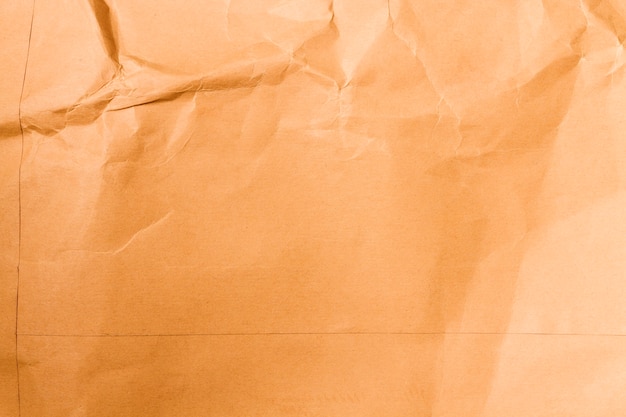 Crumpled orange paper texture with copy space