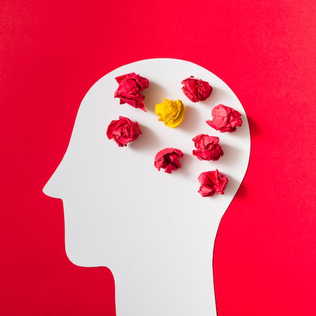 Crumpled paper over the cut out white human head on red background