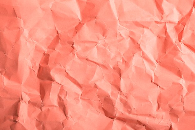 Crumpled paper texture on coral background