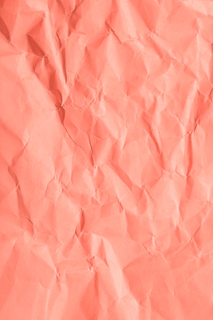 Crumpled paper texture on coral background