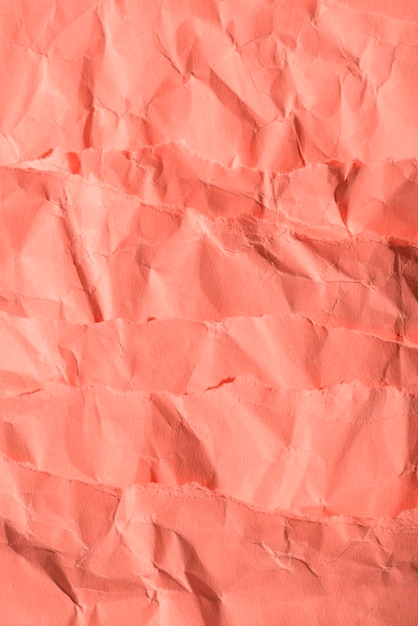 Free photo crumpled paper texture on coral background