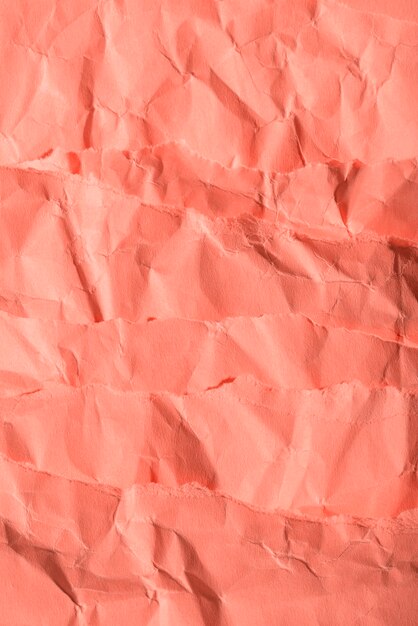 Crumpled paper texture on coral background