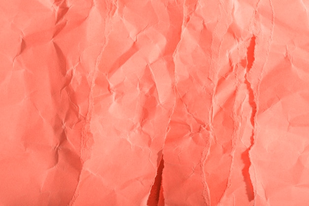 Free photo crumpled paper texture on coral background