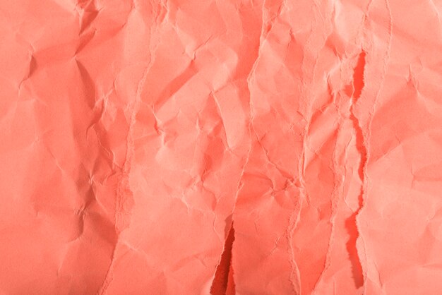 Crumpled paper texture on coral background