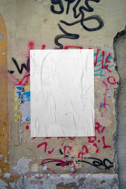 Crumpled poster on graffiti wall