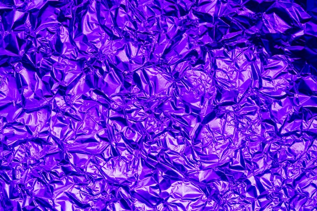 Crumpled vivid purple aluminium foil background