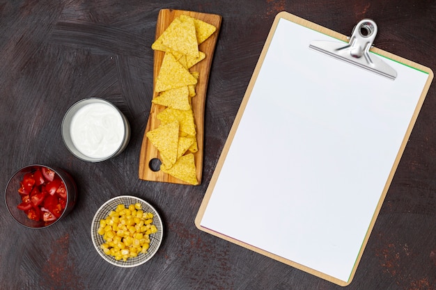 Free photo crunchy nachos vegetables clipboard and white sauces