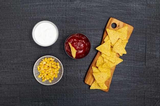 Crunchy traditional nachos with dips and corn