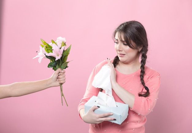 Crying woman rejecting lily bouquet while holding napkins