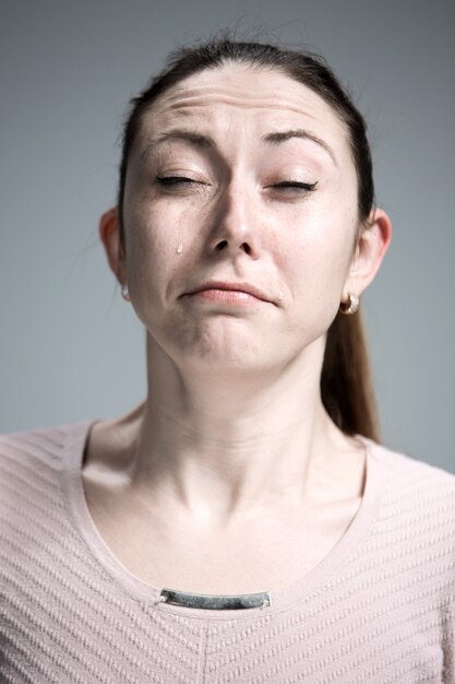 The crying woman with tears on face closeup