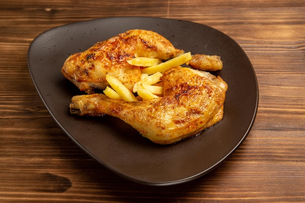 テーブルの上のフライドポテトと鶏の脚を食欲をそそる鶏の脚をクローズアップ
