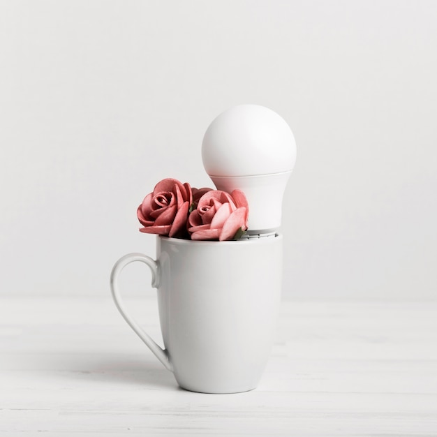 Foto gratuita cucciolo con belle rose e una lampadina