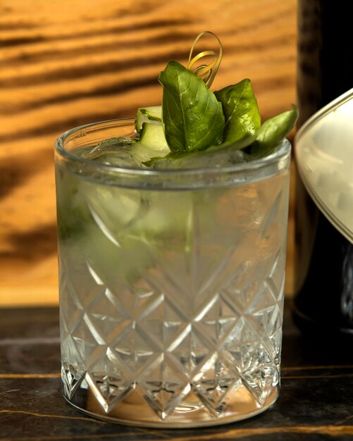 Cucumber cocktail in crystal glass garnished with basil leaves