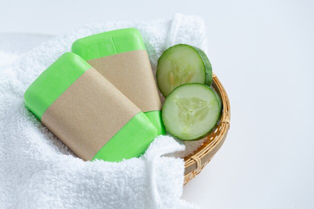 Cucumber slices and soap on white background