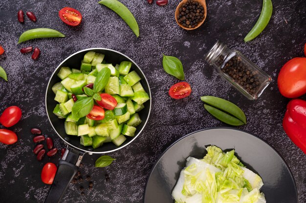 Cucumber stir-fried with tomatoes and red beans in a frying pan.