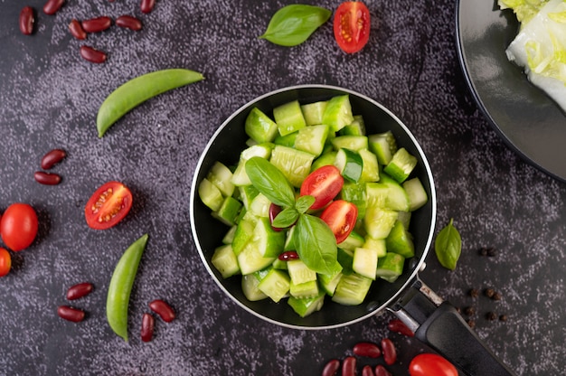 Cucumber stir-fried with tomatoes and red beans in a frying pan.