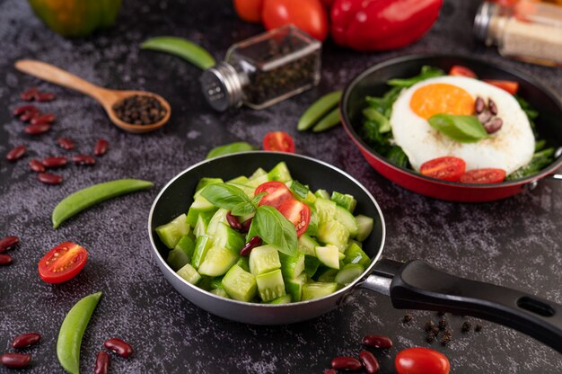 Cucumber stir-fried with tomatoes and red beans in a frying pan.