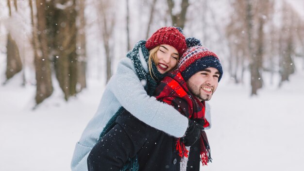 Cuddling happy couple in snowfall