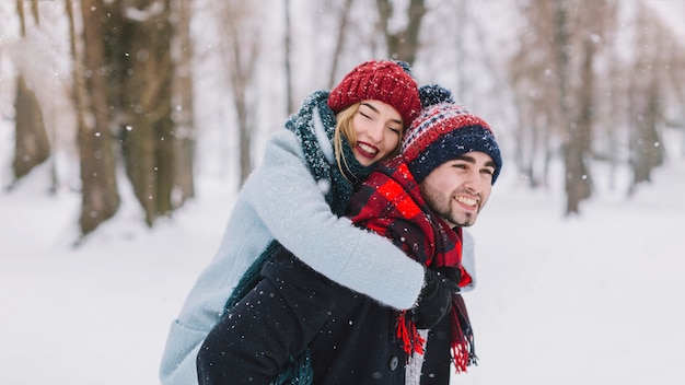 雪の中で抱き合っている幸せなカップル