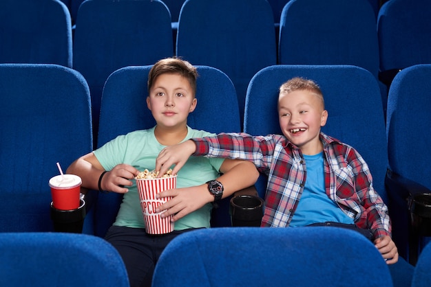 Ragazzo astuto che ruba popcorn mentre amico che guarda film