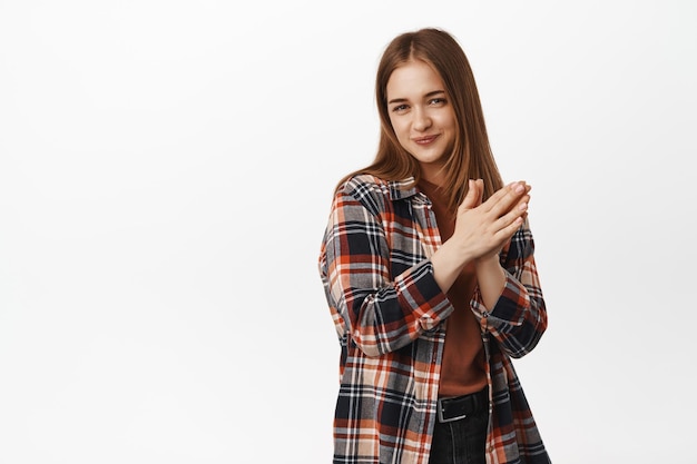 Cunning young woman has plan, rub hands and smirk devious, planning something, scheming an idea, standing against white background