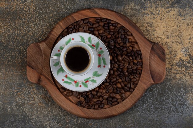 Free photo cup of aroma espresso with coffee beans on wooden board.