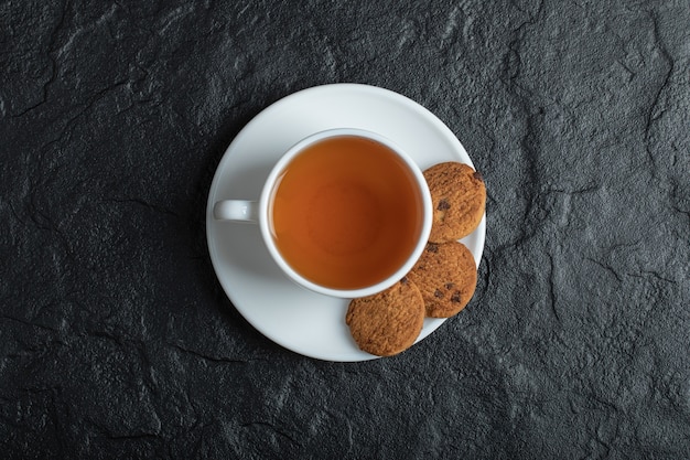Foto gratuita una tazza di tè aromatizzato con deliziosi biscotti.