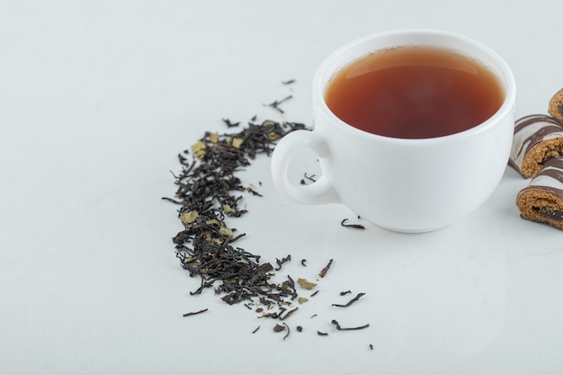 A cup of aroma tea with dried loose teas.