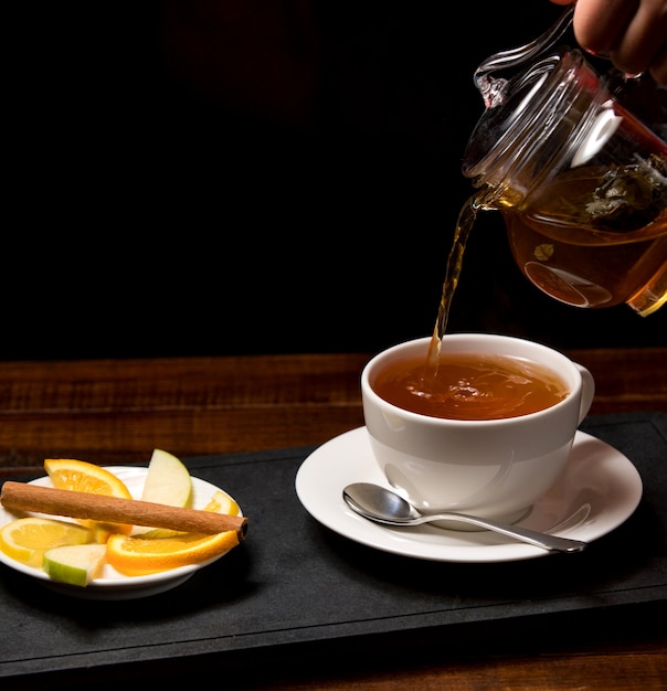 Cup of aromatic tea and bowl with lemon