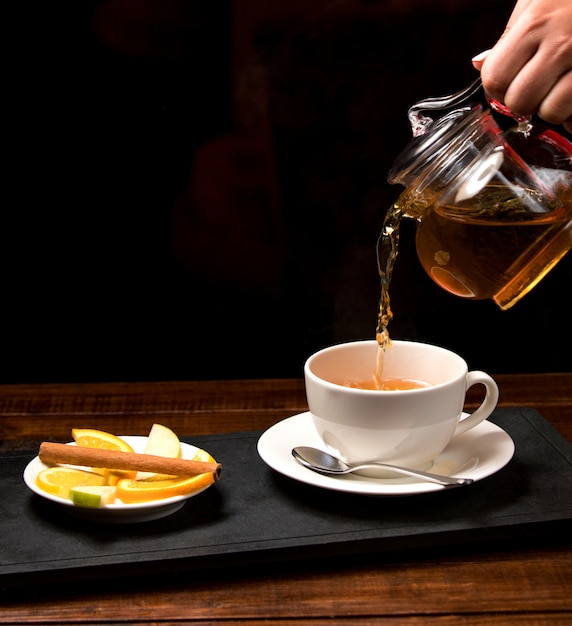 Free photo cup of aromatic tea and bowl with lemon