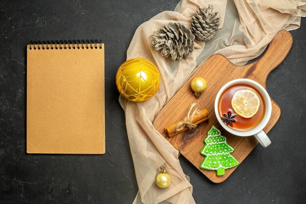 木製のまな板にレモンとシナモンライムの新年の装飾アクセサリーと紅茶のカップ