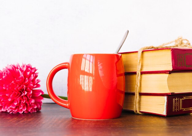 Cup next to book pile