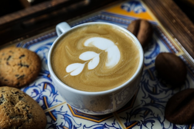 A cup of cappuccino served with cookies