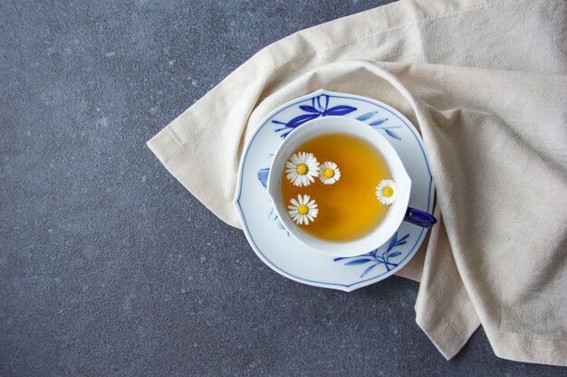 A cup of chamomile tea with cloth top view