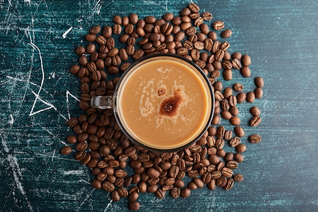 Una tazza di caffè sui fagioli, vista dall'alto.