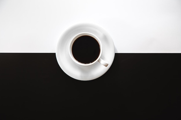 Cup of coffee on a black and white background flat lay