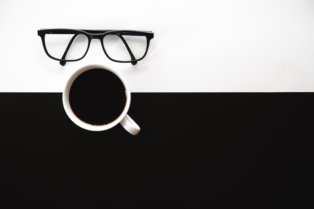 Cup of coffee on a black and white background flat lay